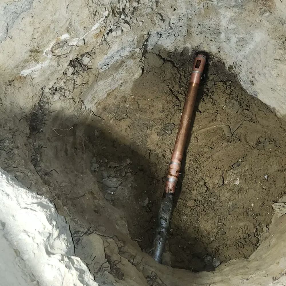 Copper pipe exposed in an open trench.
