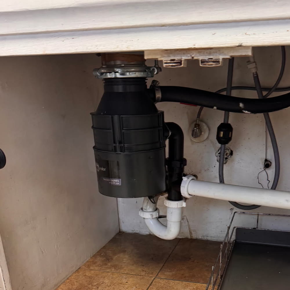 Garbage disposal with a white PVC trap.