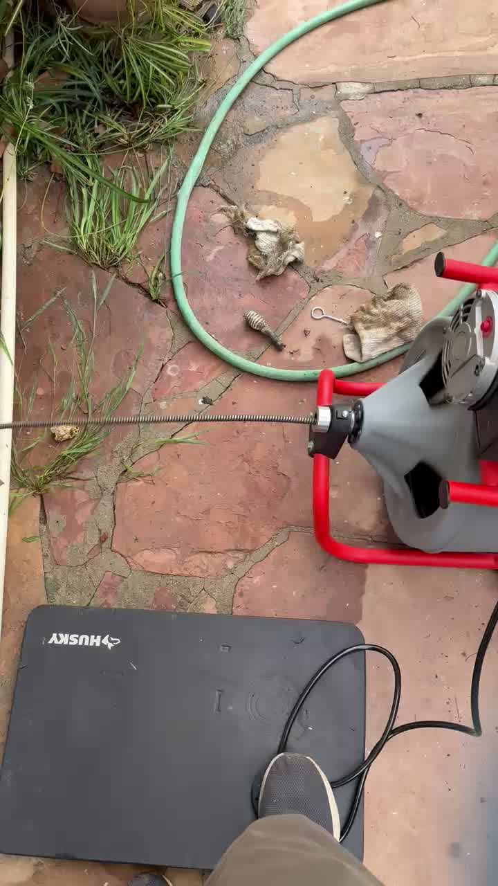 A drum drain machine running its cable to an outside cleanout, live footage.
