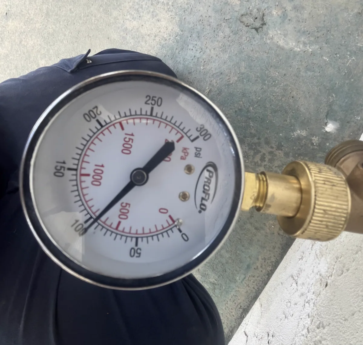 A close up of a water pressure test gauge on a hose bib with the needle past 270 psi.