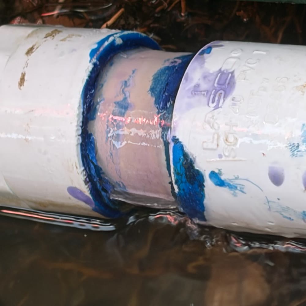 PVC line repair with new couplings in a trench.