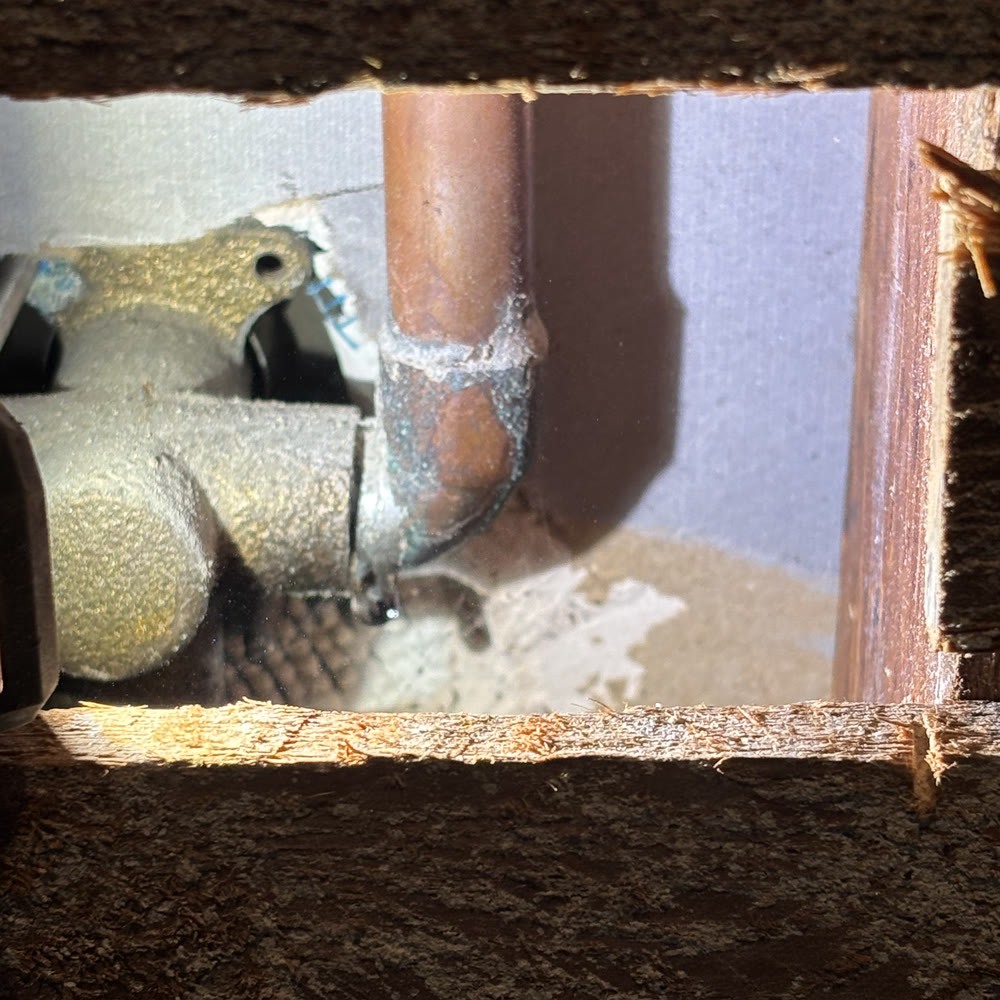 Opened shower wall exposing a leaking copper fitting.