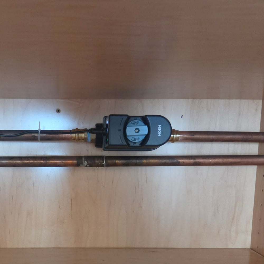 Smart water shutoff on a copper water line inside a cabinet