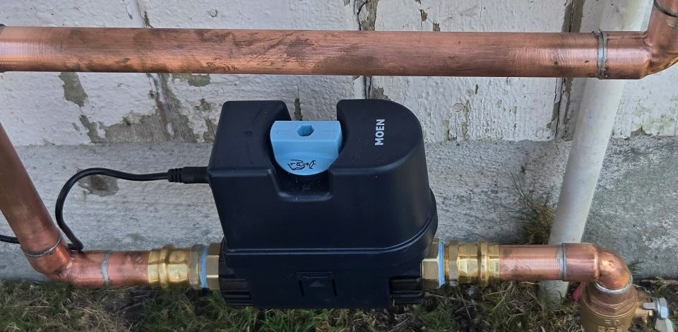 Closeup of a smart water shutoff installed on a copper water line