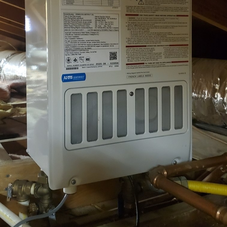Tankless water heater installed in an attic.